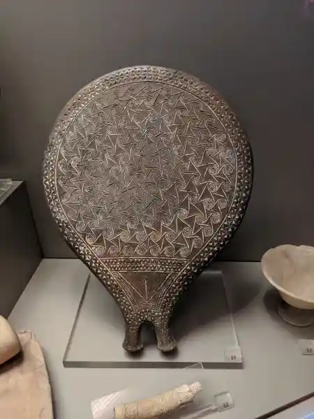 Early Bronze Age ceramic frying pan decorated with impressed spirals and incised pubic triangle from Grave 307, Syros